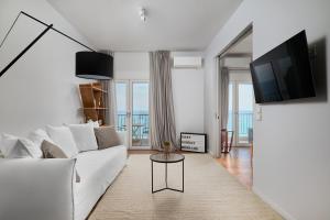 a white living room with a white couch and a table at Crete - Heraklion Sea View Apartment 1 in Heraklio Town