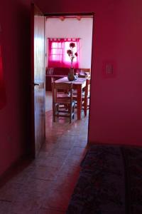 a dining room with a table and a red wall at Hospedaje BAHUINIAS II in Federación