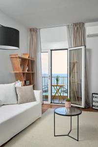 a living room with a white couch and a table at Crete - Heraklion Sea View Apartment 1 in Heraklio Town