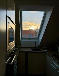 una cocina con una gran ventana sobre un fregadero en Apartmány Mikulovské zahrady, en Mikulov