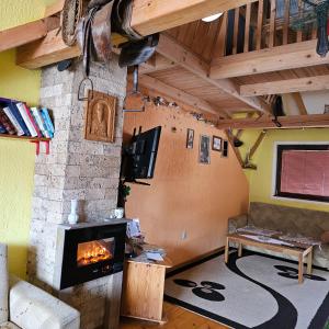 a living room with a fireplace and a couch at "Athos"apartment potkrovlje in Višegrad