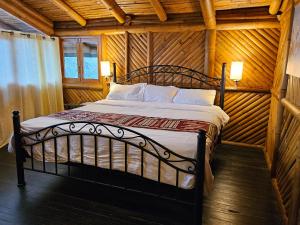 a bedroom with a bed in a log cabin at GOLDEN TREE MINDO ECO-LODGE in Mindo