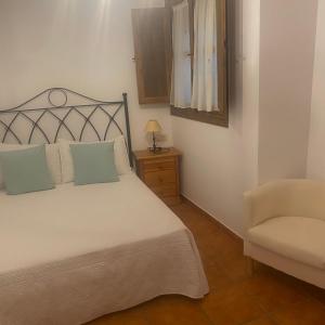 a small bedroom with a bed and a chair at Casa rural La Aldea in Cabezuela del Valle