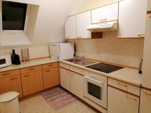 a small kitchen with white cabinets and a sink at Ferienwohnung Moni in Geiseldorf