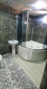 y baño con bañera y lavamanos. en Ali Baba Villası en Şahinbey