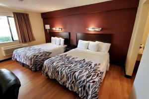 Habitación de hotel con 2 camas y ventana en Sacramento Inn & Suites en Sacramento