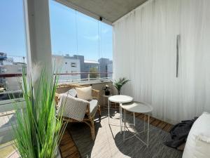 a living room with a table and chairs on a balcony at Stunning design apartment with sauna & free parking in Helsinki