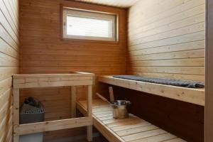 a wooden sauna with two benches and a window at Stunning design apartment with sauna & free parking in Helsinki