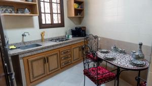 a kitchen with a sink and a table with a chair at Dar Bouzoubaa in Fez
