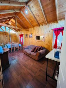 ein Wohnzimmer mit einem Sofa und einem Tisch in der Unterkunft Cabaña en linares camino el embalse ancoa in Linares