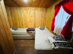 リナレスにあるCabaña en linares camino el embalse ancoaの木造キャビン内のベッド2台が備わる部屋