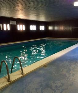 een zwembad in een gebouw met blauw water bij Superbe suite moderne avec balcon et piscine in Boulogne-Billancourt