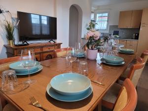 - une table en bois avec des assiettes et des verres à vin dans l'établissement Chalet Nature Park "Apartment Thun" - Self Check-in, à Thun