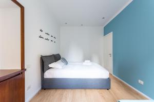 um quarto com uma cama com lençóis brancos e pássaros na parede em Milano Apartments Navigli em Milão