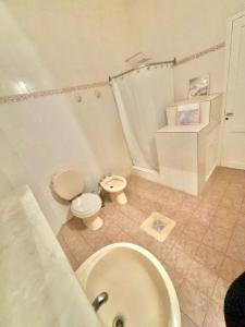 a bathroom with a toilet and a sink and a tub at Casa Blanca 2 in Santiago del Estero