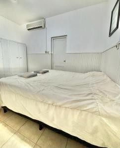 1 cama blanca grande en un dormitorio blanco en Casa Blanca 2 en Santiago del Estero