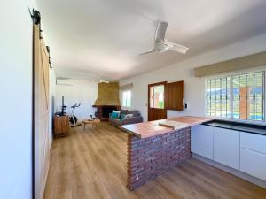 cocina y sala de estar con ventilador de techo en Casa de campo Sierra Gorda, en Málaga