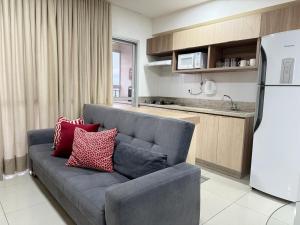 a living room with a couch and a kitchen at Apto c/vista próx a faculdade /hospitais PC2302 in Goiânia