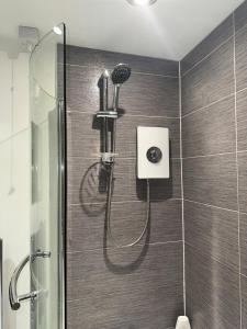 a shower with a shower head in a bathroom at Single Room In A Cosy House In Pitsea in Pitsea