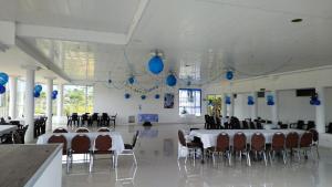 uma sala com mesas e cadeiras e balões azuis em Hotel y Cabañas Rio Mayo em Chachagüí