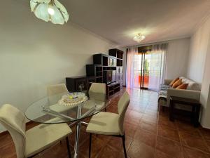 sala de estar con mesa de cristal y sillas en Alquilaencanarias Sotavento Paradise, en Granadilla de Abona