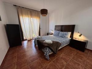 Un dormitorio con una cama y una ventana grande. en Alquilaencanarias Sotavento Paradise, en Granadilla de Abona 7 fotos más