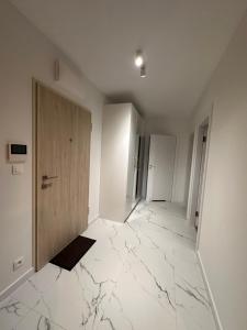 un couloir vide avec un sol en marbre et une porte dans l'établissement D&M Apart Butikowa Kamienica 9, à Białystok