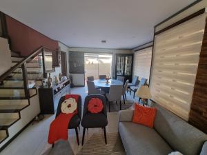 uma sala de estar com um sofá, uma mesa e cadeiras em Comodidad y Elegancia em Cochabamba