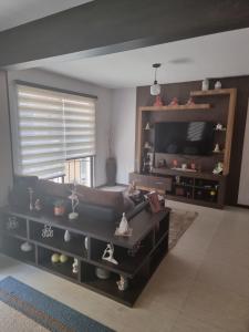 sala de estar con sofá y TV en Comodidad y Elegancia en Cochabamba