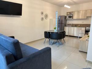 Una sala de estar con un sofá azul y una cocina. en Palermo Apartments, en Buenos Aires