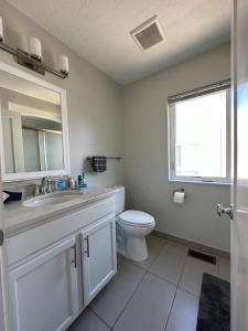 a bathroom with a toilet and a sink and a mirror at Luxury Downtown Townhome Unit 13 in Cleveland