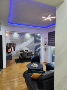 een woonkamer met een blauw plafond bij Apartman Relja in Novi Banovci