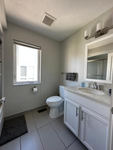 a bathroom with a toilet and a sink and a window at Luxury Downtown Townhome Unit 13 in Cleveland