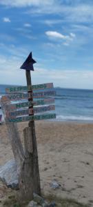 uma placa na praia com um guarda-sol em QUINTAS DA BARRA BNB a 30m da praia em Balneário Barra do Sul