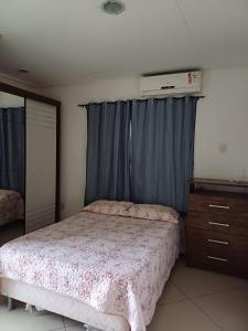 - une chambre avec un lit et une commode dans l'établissement Lindo AP inteiro de um quarto próximo a praia., à Vila Velha