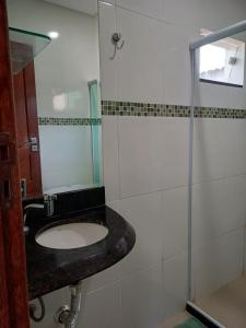 La salle de bains est pourvue d'un lavabo et d'une douche. dans l'établissement Lindo AP inteiro de um quarto próximo a praia., à Vila Velha
