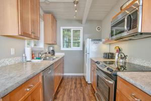 a kitchen with wooden cabinets and stainless steel appliances at Oceanview Home with Hot Tub, Fenced Yard, and Dog-Friendly in Lincoln City