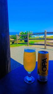 um copo de cerveja e uma lata na mesa em QUINTAS DA BARRA BNB a 30m da praia em Balneário Barra do Sul