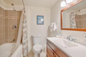 a bathroom with a toilet and a sink and a mirror at Oceanview Home with Hot Tub, Fenced Yard, and Dog-Friendly in Lincoln City