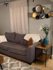 a living room with a gray couch and a table at Be our guest BOHO 2.0 in Charlotte