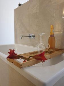 a bottle of champagne and a glass on a bathroom sink at Herdade dos Sepol in Odivelas