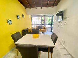 una sala da pranzo con pareti gialle e tavolo e sedie di apartamentos casa Margarita en laureles estadio su hogar en Medellin a Medellín
