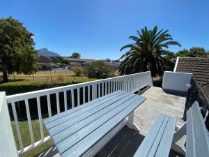 a wooden bench sitting on a white railing at Doordrift Extension in Cape Town