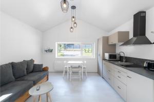 eine Küche und ein Wohnzimmer mit einem Sofa und einem Tisch in der Unterkunft Le Petit Bouchot & Jacuzzi privatif proximité Gerardmer & La Bresse in Rochesson