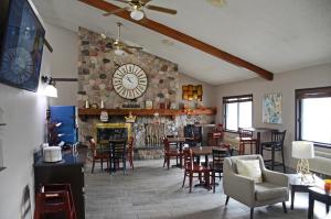 a dining room with a large clock on a stone wall at Baymont by Wyndham Waupun in Waupun