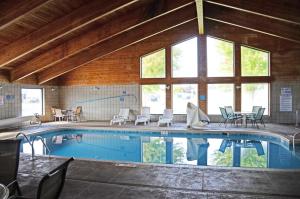 a large swimming pool with chairs and a table at Baymont by Wyndham Waupun in Waupun