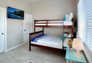 a small bedroom with two bunk beds and a table at Multi Family! 2 min walk to Beach! EV Charger! in Oceano