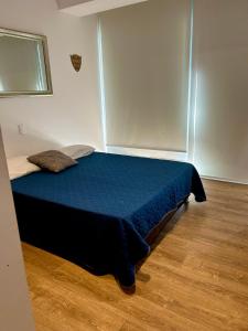 1 dormitorio con 1 cama azul en una habitación en Departamento en zona real a 5 mins de Andares, en Guadalajara