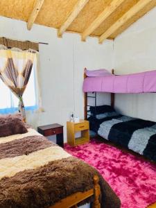 1 dormitorio con 2 literas y techo rosa en Hospedaje Marisol, en Pichicolo