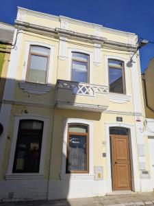 a yellow building with windows and a door at Figueira da Foz Luxury Villa Suite Room in Buarcos